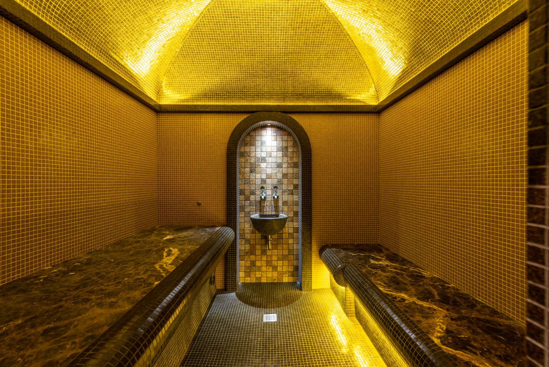 Maghrebin woman in traditional attire giving hammam treatment at spa in Lutterbach, Germany