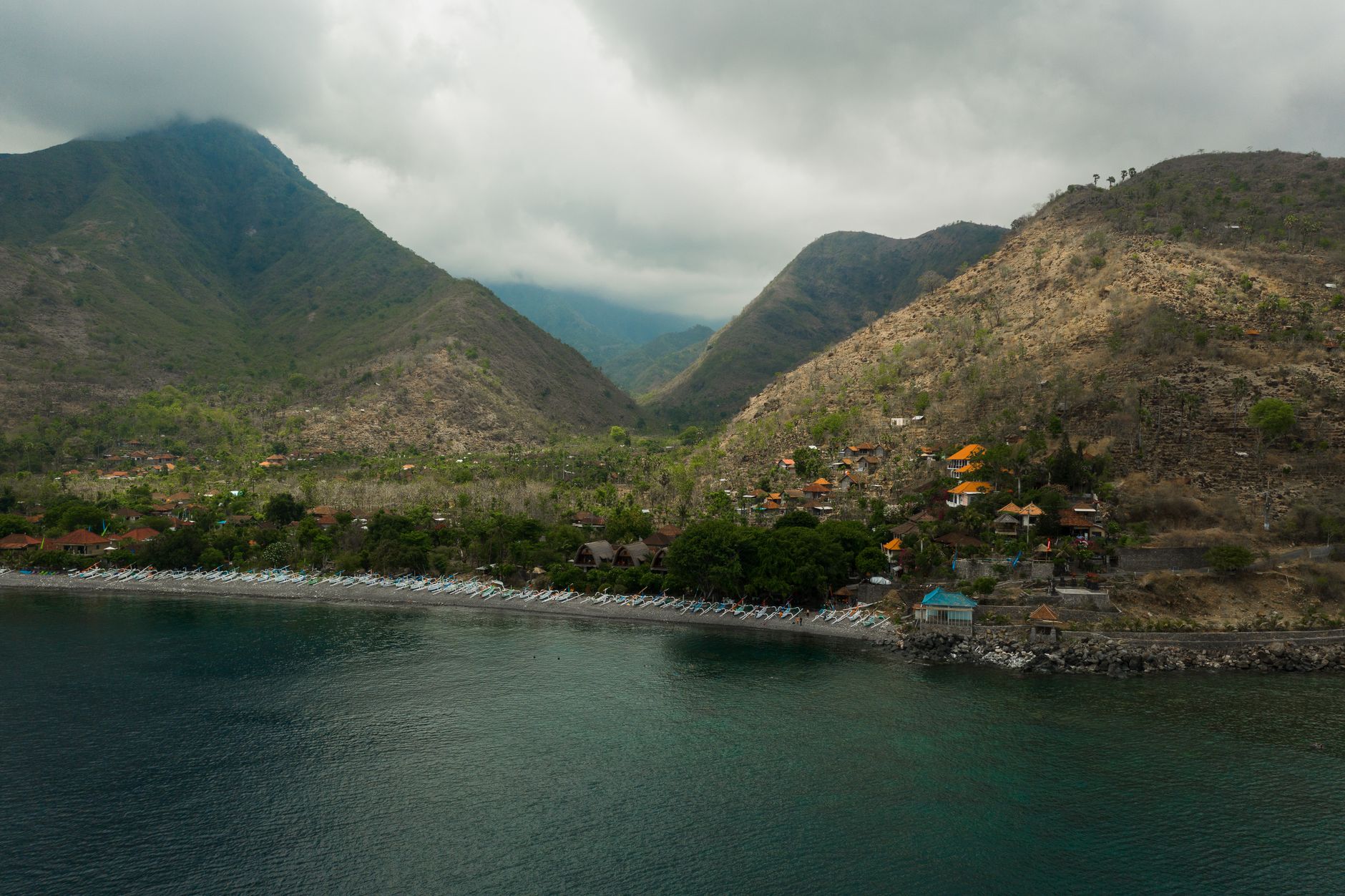 Famille voyagère dans un paysage montagneux avec palmes et océan en arrière-plan