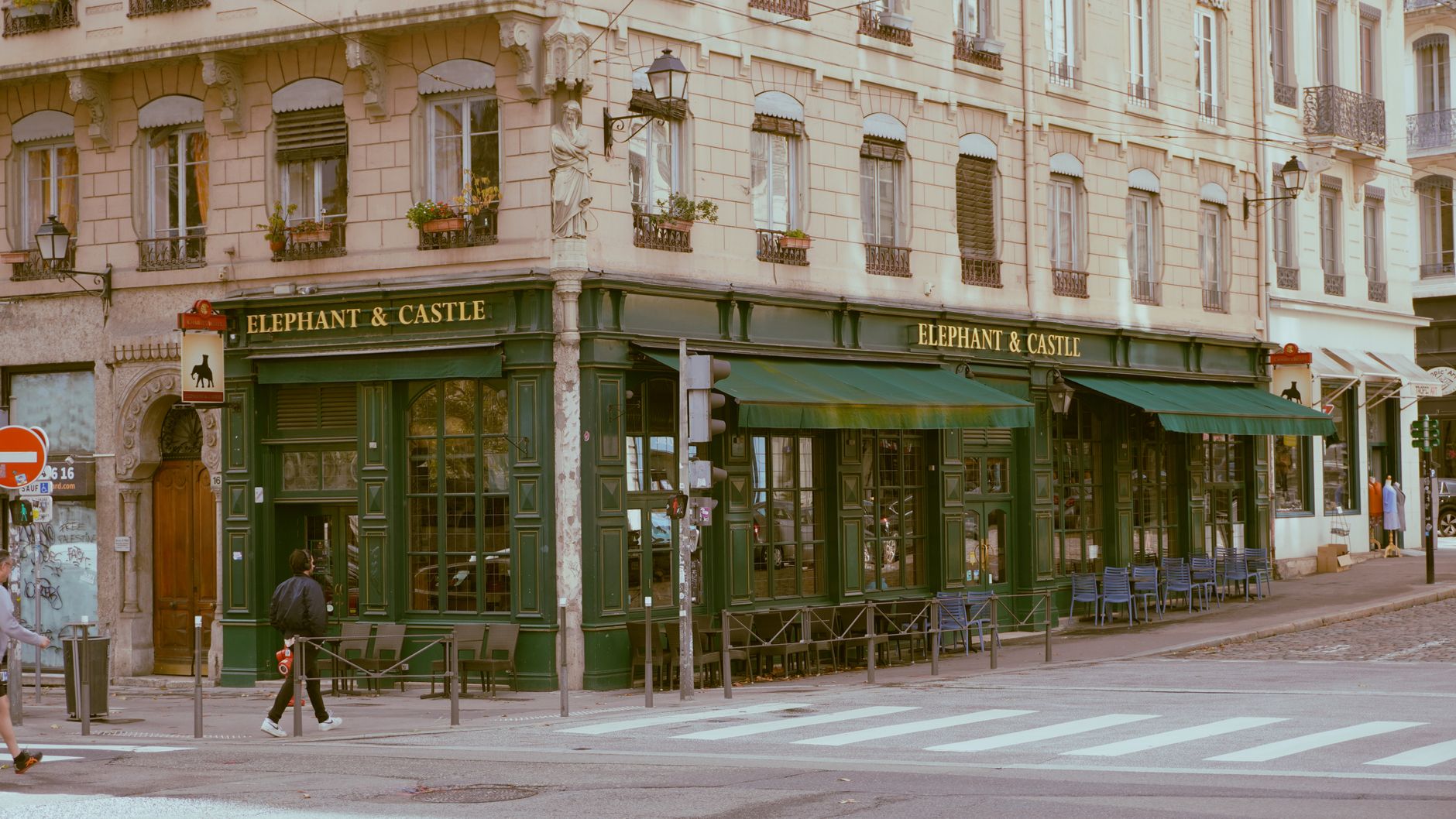 Famille algérienne assise autour d'une table de restaurant lyonnais servie de plats combinant les saveurs de la cuisine algér